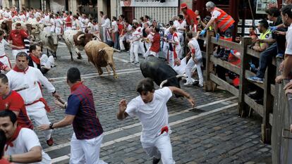 Los participantes corren delante de los toros del primer encierro de las fiestas de San Fermín, de la ganadería Cebada Gago.