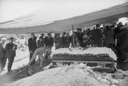 El actor Steve McQueen besa la tumba de Bruce Lee en el funeral celebrado en Seattle en 1973. Al fondo, sentados, la viuda de Lee, Linda C. Emery, y sus hijos Brandon y Shannon.