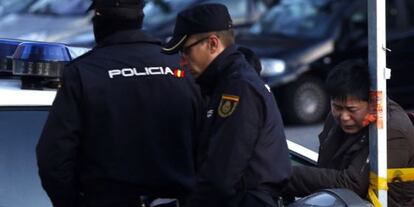 Dos agentes, en el exterior de la tienda regentada por chinos donde se cometió el homicidio.