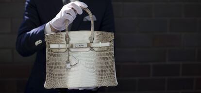 Un empleado de Herm&eacute;s muestra un bolso del modelo Birkin de la firma.