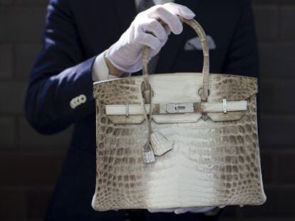 Un empleado de Herm&eacute;s muestra un bolso del modelo Birkin de la firma.