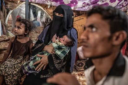 Arwa Saleh junto a su hijo recién nacido en su vivienda de cartón, maderas y chapas en el campo informal de personas desplazadas en el Distrito de Mahala, en Yemen. Ella, su marido, Mohammed Ali Salem, y sus hijos huyeron de Hodeida, al norte del país a causa del conflicto. No tuvieron tiempo ni de coger sus pertenencias. Su hijo pequeño nació cuando ya estaban fuera de su ciudad, fueron al hospital y tuvieron que pagar 20.000 reales yemeníes para la atención médica. La madre cuenta que la situación en el campo, en el que viven unas 300 familias, es muy difícil y que ha habido enfermedades como el dengue. 