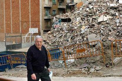 Un vecino del Carmel pasa por la zona afectada por los derribos, con una importante acumulación de escombros.