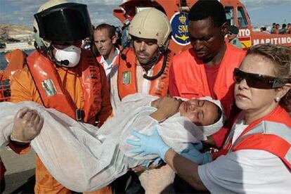 Miembros de equipos de rescate trasladan a un inmigrante con síntomas de hipotermia ayer en Almería.