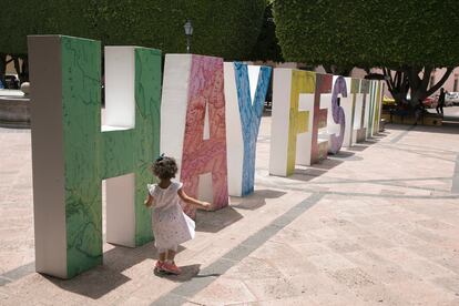 niña camina junto a las letras que anuncian el Hay Festival en el centro de la ciudad de Querétaro,