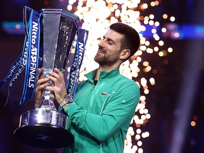 Serbia's Novak Djokovic celebrates with a trophy after winning ATP final against Italy's Jannik Sinner.