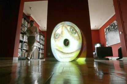 El coleccionista Emilio Pi camina por una sala de su vivienda junto a <i>Sacc</i> (2004), obra del artista estadounidense Tony Oursler.