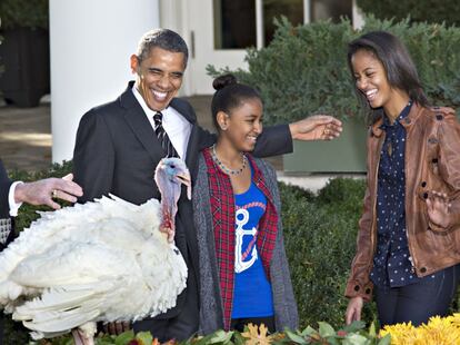 Barack Obama, con sus hijas Sasha y Malia, delante del pavo que ha sido indultado.