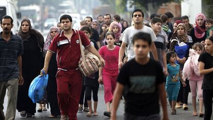 Decenas de personas han perdido la vida en repetidos ataques israelíes sobre viviendas de este populoso barrio, objeto aún de fuertes bombardeos a esta hora del día. En la imagen, vecinos del barrio de Shiyahiya abandonan sus casas, el 20 de julio de 2014.