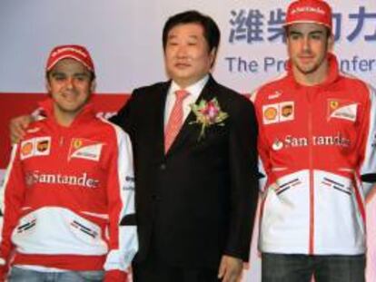 Los pilotos de Ferrari Felipe Massa (i) y Fernando Alonso (d) posan junto a Tan Xuguang, presidente ejecutivo de Weichai Power, durante la presentación de la alianza publicitaria entre la firma china y la escudería en Shanghái.
