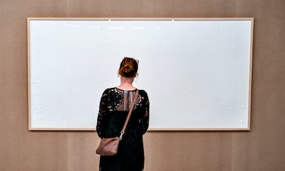 A woman looks at the painting 'Take the Money and Run,' by Jens Haaning, at the Kunsten Museum in Aalborg, Denmark.