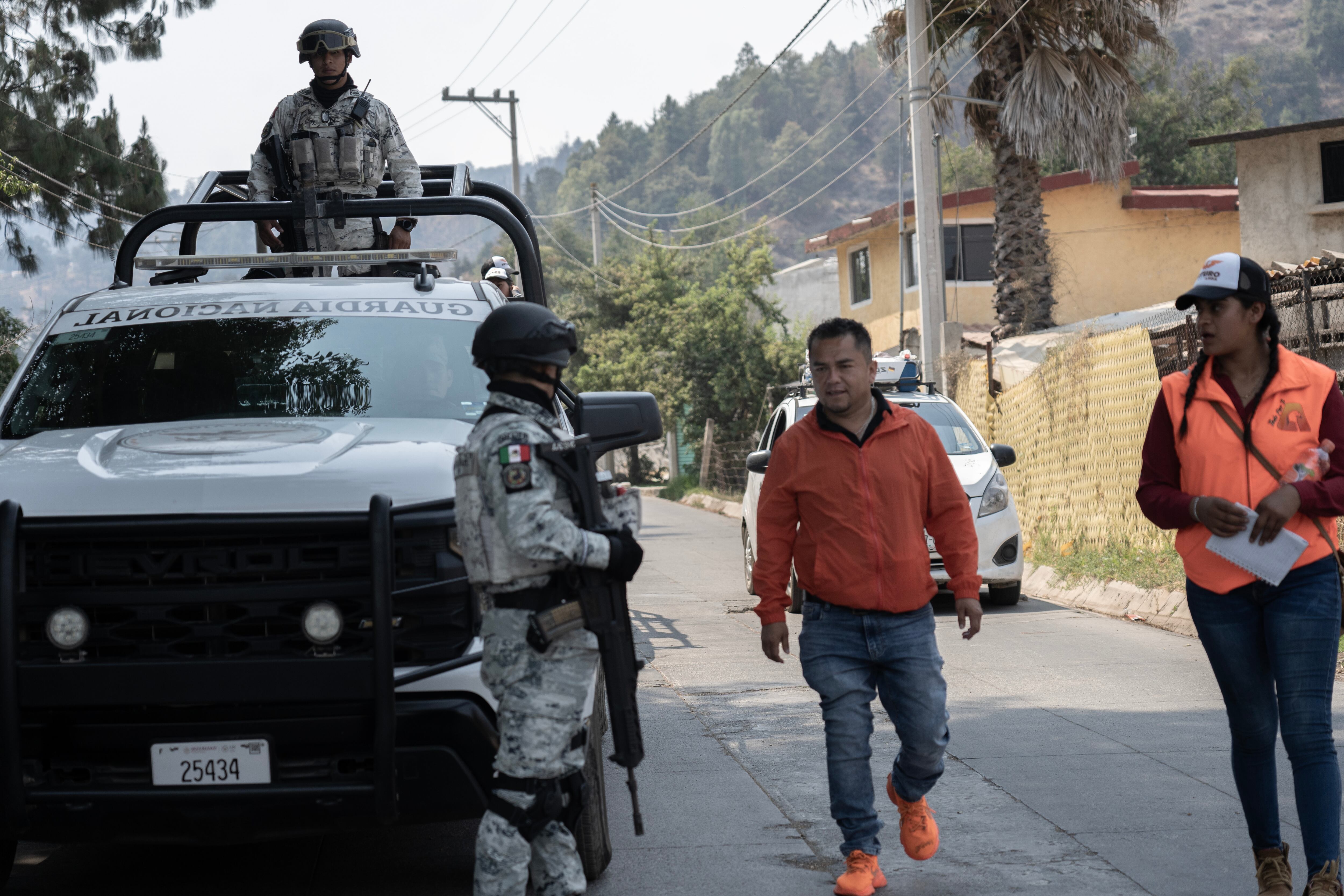 Un candidato a la alcaldía de Amanalco (Estado de México) es escoltado durante su campaña, luego de un atentado en abril de este año.