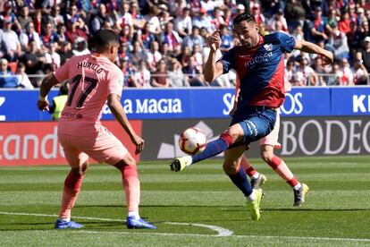 El delantero del Huesca Enric Murillo (derecha) con el balón ante el defensa colombiano del Barcelona, Jeison Faiban Murillo.