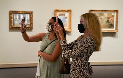 Visitantes fotografían lienzos de la exposición sobre Edgar Degas en la National Gallery of Art de Washington, en julio de 2020.