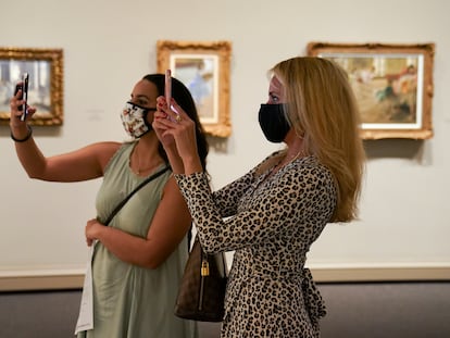 Visitantes fotografían lienzos de la exposición sobre Edgar Degas en la National Gallery of Art de Washington, en julio de 2020.