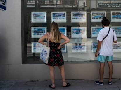 Dos personas observan el escaparate de una inmobiliaria en Palma, el pasado 1 de julio.