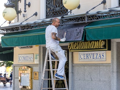 Un trabajador pinta un establecimiento en Madrid.