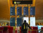 Un pasajero en el panel de salidas del aeropuerto de Barajas (Madrid), en diciembre.