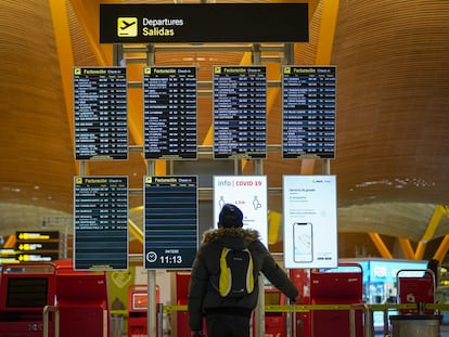 Un pasajero en el panel de salidas del aeropuerto de Barajas (Madrid), en diciembre.