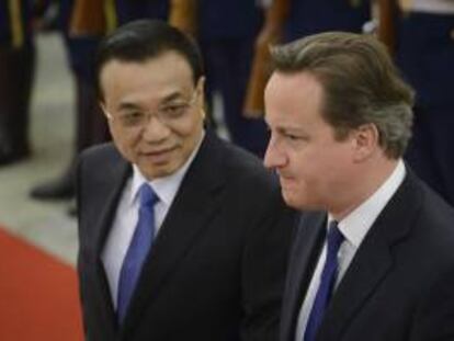 El primer ministro británico, David Cameron (dcha), y su homólogo chino, Li Keqiang (izda), inspeccionan la guardia de honor durante la ceremonia de bienvenida en el Gran Palacio del Pueblo en Pekín (China) hoy, lunes 2 de diciembre.