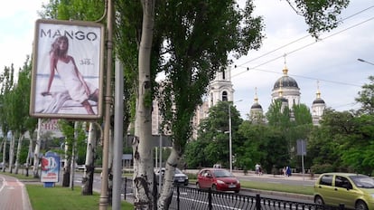 Tráfico en una de las avenidas de Donetsk. En primer término, un cartel publicitario de moda de mujer.