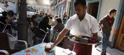 Un camarero sirve una cerveza en una terraza de la calle Argumosa.  