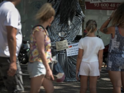 Un artista callejero de Las Ramblas de Barcelona publicitaba su número de móvil para recibir donaciones por Bizum, el jueves.