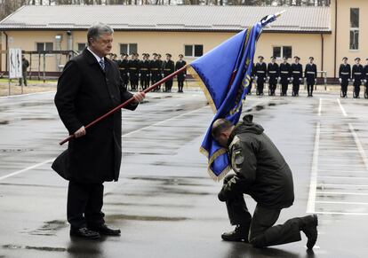 El presidente de Ucrania, Petro Poroshenko, a la izquierda, entrega la bandera de una unidad militar a un oficial, en una base militar en las afueras de Kiev (Ucrania).