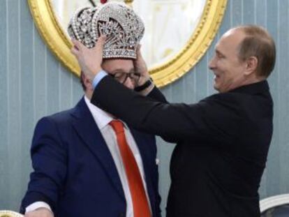 El presidente ruso, Vladímir Putin (derecha), coloca una corona al director artístico del teatro de variedades de Moscú, Gennady Khazanov, en Moscú.