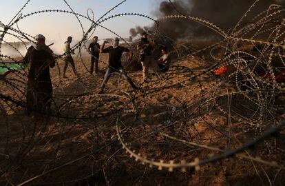 Palestinos lanzan piedras a las tropas israelíes durante una protesta que pide levantar el bloqueo israelí en Gaza y exigir el derecho a regresar a su país de origen, en la valla fronteriza Israel-Gaza en el sur de la Franja de Gaza, el 12 de octubre de 2018.