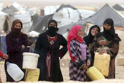 Refugiadas sirias esperan para llenar sus bidones de agua en un campamento en el paso fronterizo de Al-Hadalat, cerca de Royashed, Jordania, en mayo de 2016. 