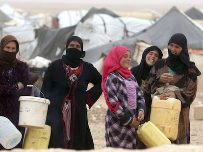 Refugiadas sirias esperan para llenar sus bidones de agua en un campamento en el paso fronterizo de Al-Hadalat, cerca de Royashed, Jordania, en mayo de 2016. 