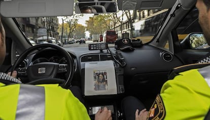 Dos agents de la Guàrdia Urbana en un cotxe patrulla.