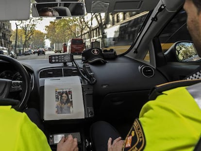 Dos agents de la Guàrdia Urbana en un cotxe patrulla.