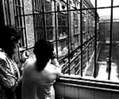 Dos presas tras un ventanal con rejas de la cárcel de Yeserías, Madrid