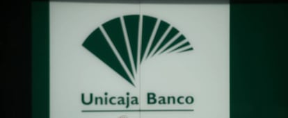 Una mujer pasa por delante de una oficina de Unicaja Banco. 