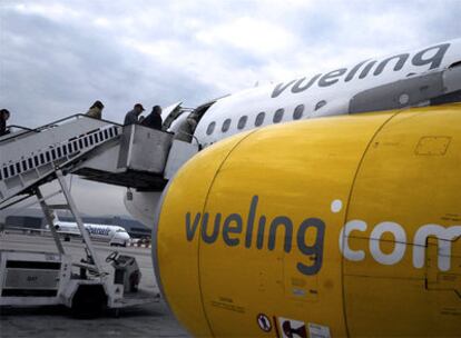 Pasajeros acceden a un avin de la compa?a Vueling en el aeropuerto barcelons de El Prat.