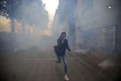 Una mujer huye del gas lacrimógeno que la policia ha lanzado en la manifestación contra la reforma laboral, en Nantes.