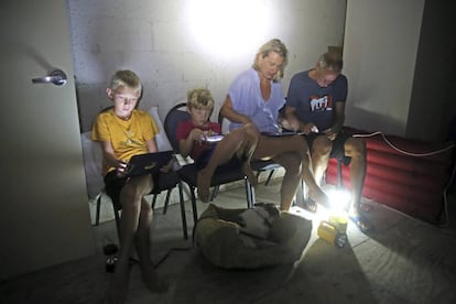 Los miembros de la Blinckman utlizan sus dispositivos móviles mientras se resguardan en una habitación en Key West (Florida).