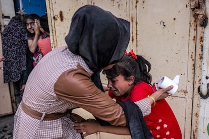 Una mujer consuela a una niña bajo shock tras un ataque israelí en Gaza, el pasado 29 de abril. 