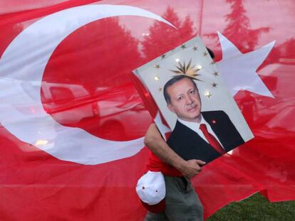 Un seguidor de Tayyip Erdogan, presidente turco, transporta una foto suya, ante la sede del partido AKP, en Estambul.