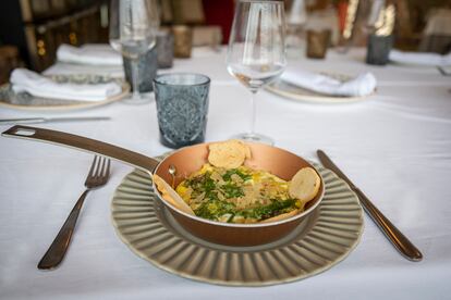 Sartén de mar, huevos al plato con anémonas de mar (ortiguillas) acompañada de lechuga de mar, salicornia, crujiente de filo y tostas de pan en el Restaurante Willy en Palmones (Cádiz).