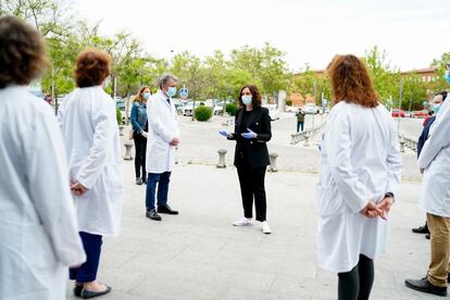 Isabel Díaz Ayuso, habla con varios profesionales sanitarios tras guardar un minuto de silencio en la puerta del Hospital Universitario Fundación Alcorcón, el 4 de mayo.