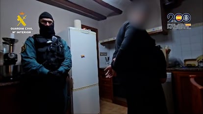 Un guardia civil custodia a un detenido en la Operación Napoleón-Aguazul que ha permitido desmantelar una red de trata de seres humanos en una imagen facilitada por Interior.