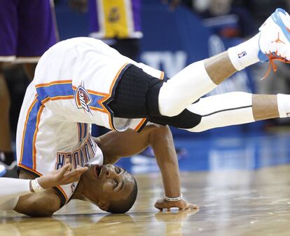 El base de Oklahoma, Russell Westbrook, da una voltereta en la pista después de encestar.