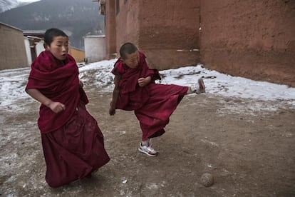Dos jóvenes monjes juegan al fútbol fuera de su albergue durante el ritual.