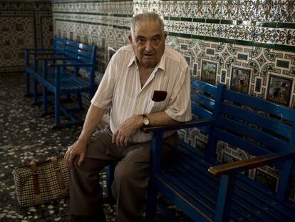 Macario Garc&iacute;a Consuegra, maquinista jubilado, en la sala de espera de Alc&aacute;zar de San Juan, decorada con azulejos alusivos al Quijote.