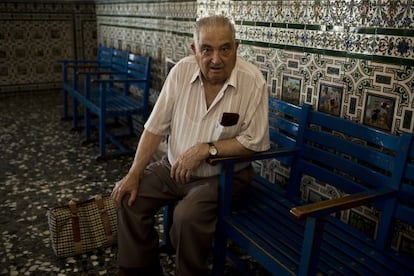 Macario Garc&iacute;a Consuegra, maquinista jubilado, en la sala de espera de Alc&aacute;zar de San Juan, decorada con azulejos alusivos al Quijote.