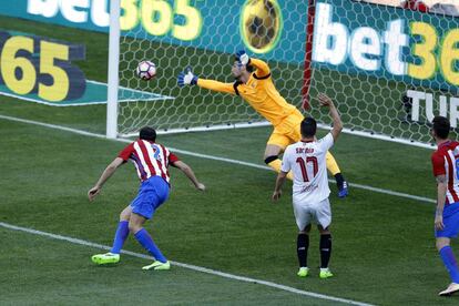 Diego Godin, del Atletico Madrid, deja atrás el portero del Sevilla Sergio Rico.