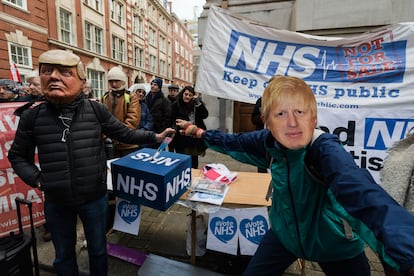 Manifestantes con máscaras de Donald Trump y Boris Johnson participan en una protesta exigiendo que el NHS sea excluido de cualquier acuerdo comercial posterior al Brexit en Londres, el 9 de diciembre de 2019.